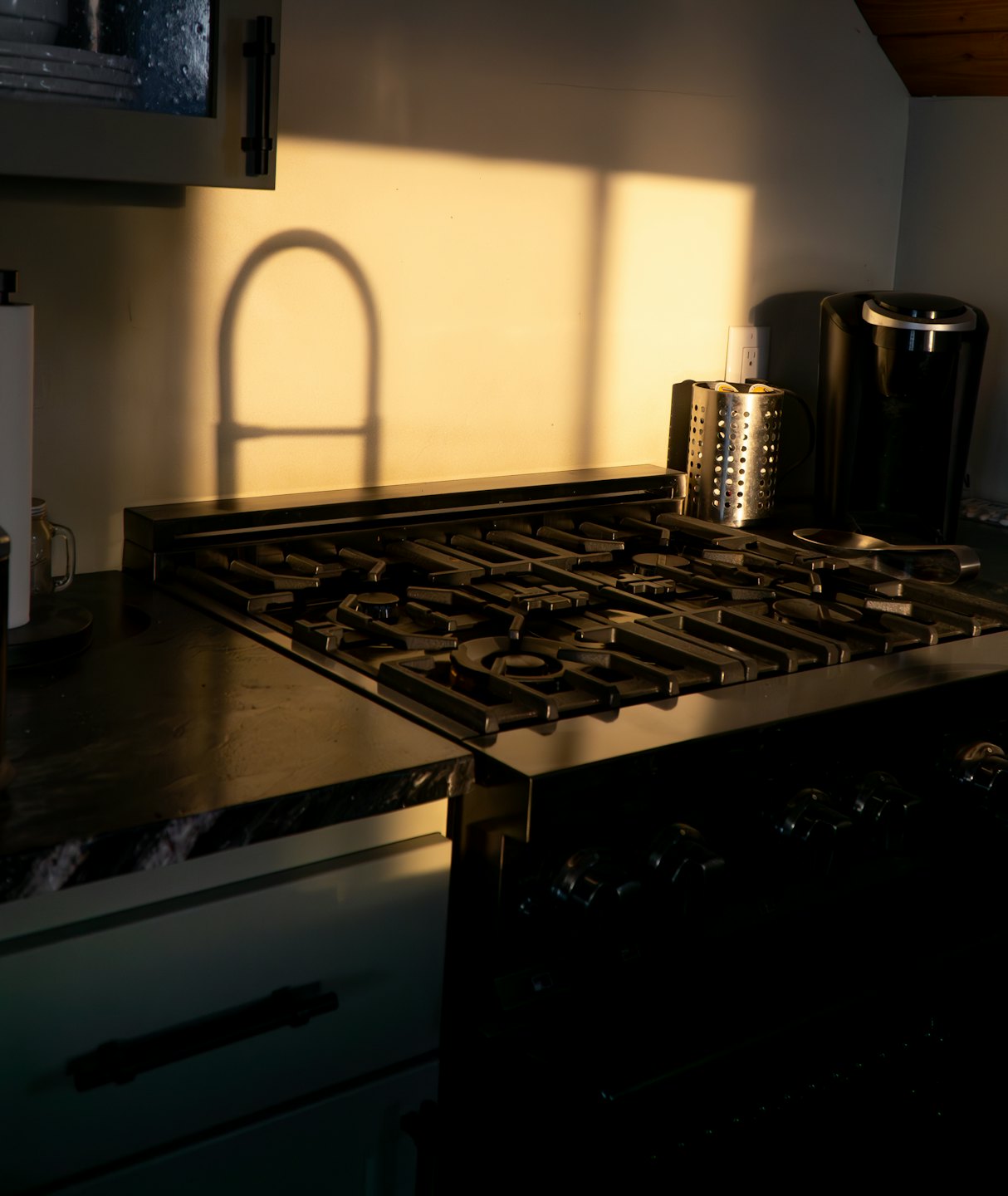 Sonnenlicht strömt auf eine moderne Küchentheke und einen Gasherd.